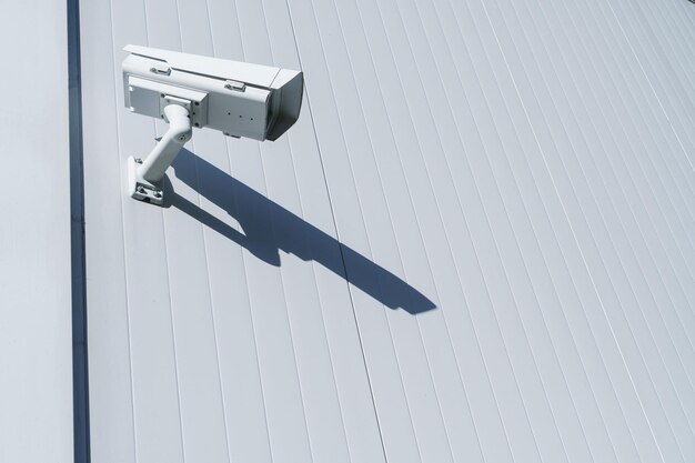 Câmera de cftv na parede do prédio para monitoramento e proteção. conceito de sistema de controle de segurança total.