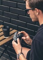 Câmera de filme vintage e um copo de café em uma mesa de madeira