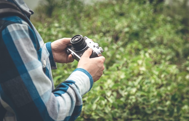 Câmera de filme vintage em mãos masculinas em uma caminhada na natureza