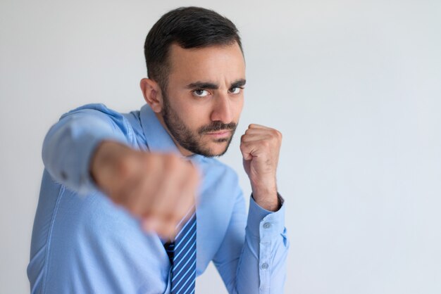 Câmera de perfuração agressiva jovem empresário barbudo