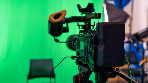 Câmera de vídeo profissional em um suporte com chromakey verde em um estúdio