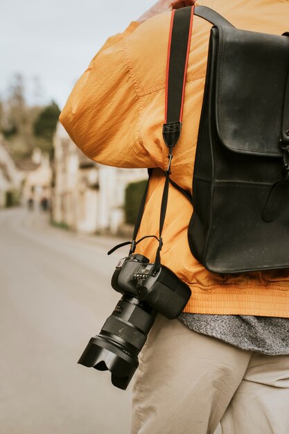 Câmera DSLR com alça pendurada no ombro do fotógrafo