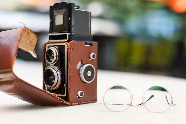 Câmera vintage e óculos na mesa