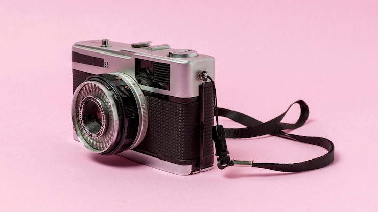 Foto grátis câmera vintage em fundo rosa