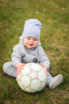 Caminhada de verão, garoto na natureza. família do esporte. um menino jogar futebol com uma bola.
