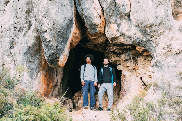 Foto grátis caminhantes na frente da caverna