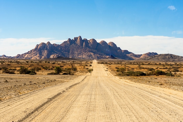 Caminho de estrada para as montanhas Spitzkoppe. O Spitzkoppe, é um grupo de picos de granito careca localizados no deserto de Swakopmund Namib - namíbia