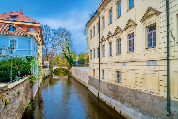 Canal que flui entre edifícios perto do Muro de Lennon em Mala Strana, Praga, Tcheca