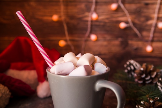 Caneca cinza com tubo de plástico e marshmallows