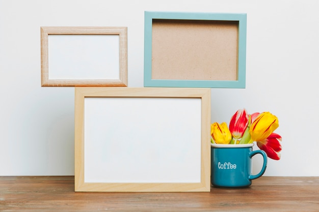 Foto grátis caneca com tulipas perto de quadros