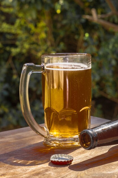 Caneca de alto ângulo com pouca espuma em cima de cerveja