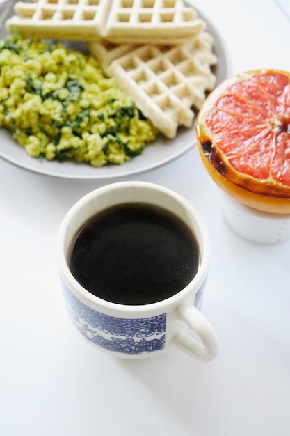 Caneca de cerâmica branca com café e comida saudável