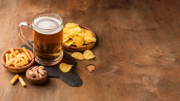 Foto grátis caneca de cerveja de ângulo alto e batatas fritas