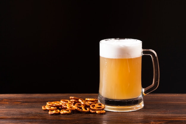 Caneca de cerveja de close-up com pretzels