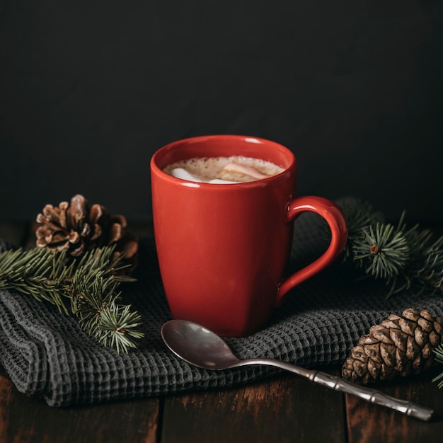 Caneca frontal com chocolate quente e pinhas