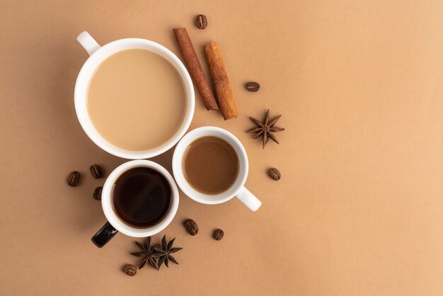 Canecas com café com canela e erva-doce ao lado