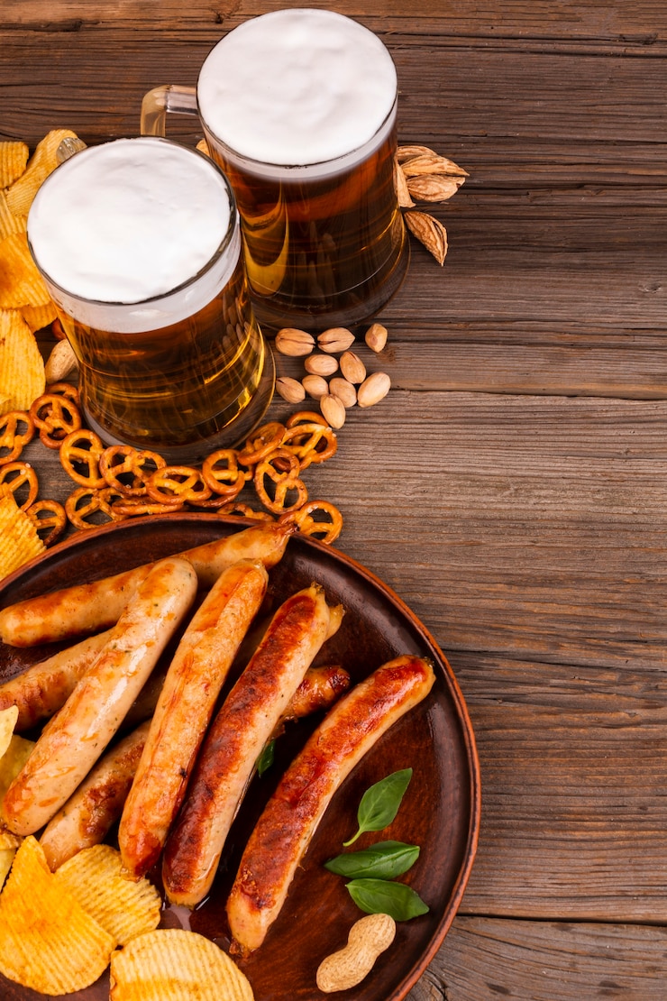 Foto grátis canecas de cerveja e prato com salsichas