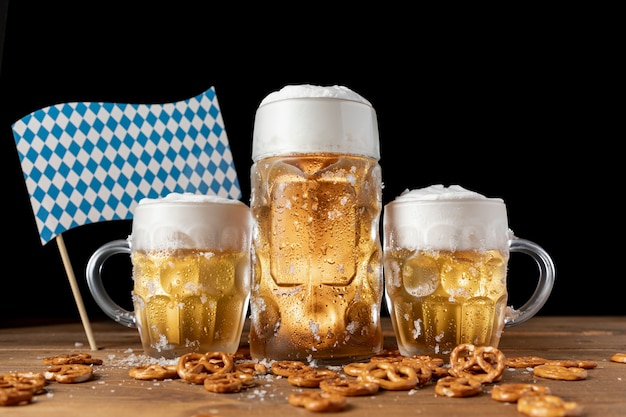 Canecas de cerveja Oktoberfest com lanches em uma tabela
