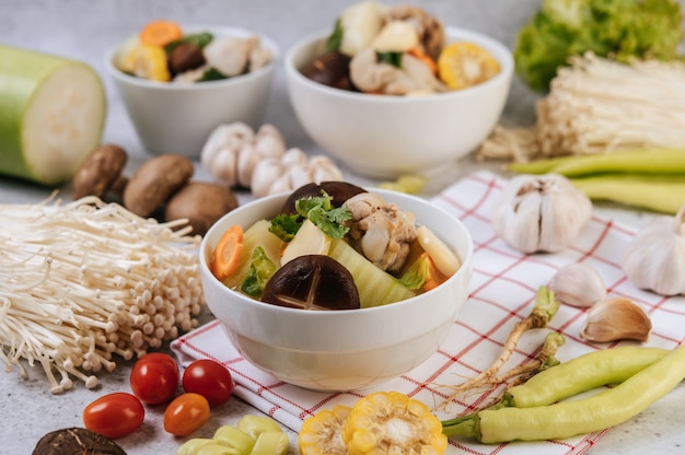 Canja de galinha com milho, cogumelo shiitake, cogumelo enoki e cenoura.