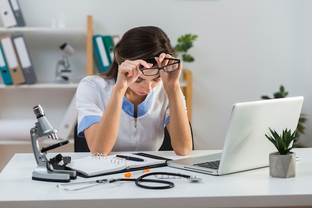 Foto grátis cansado médica tirando os óculos