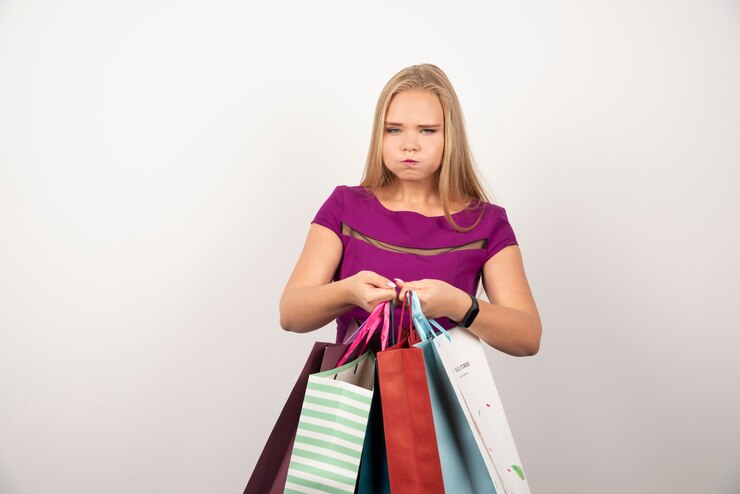 Foto grátis cansado shopaholic segurando sacolas coloridas.