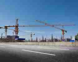 Foto grátis canteiro de obras com guindastes de encontro ao céu azul