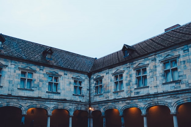 Foto grátis canto de um antigo edifício antigo com as luzes acesas sob um céu azul durante o dia