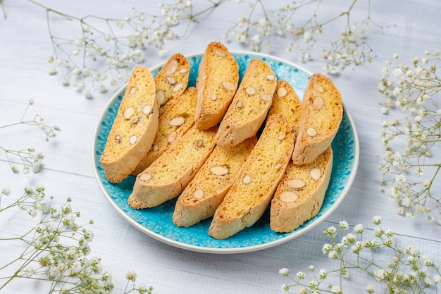 Cantuccini de biscoitos tradicionais da toscana italiana com amêndoas, uma xícara de café na luz