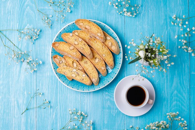 Cantuccini de biscoitos tradicionais da Toscana italiana com amêndoas, uma xícara de café na luz