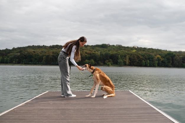 Foto grátis cão de treinamento de mulher de vista lateral