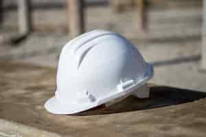 Foto grátis capacete de construção branco no chão sob a luz do sol