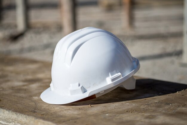 Capacete de construção branco no chão sob a luz do sol