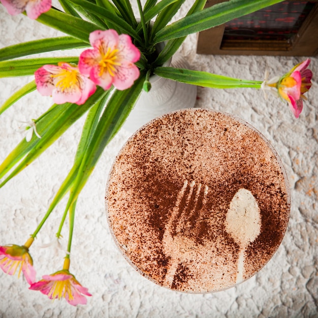 Foto grátis cappuccino de vista superior com a inscrição com vaso com flores e porta-guardanapos em copo de coquetel