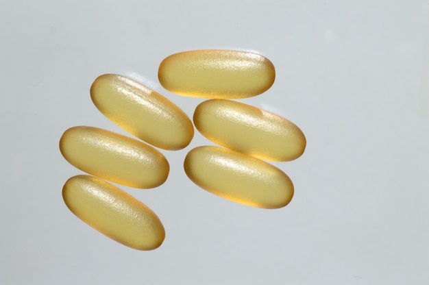 Cápsulas farmacêuticas variadas. pilha de vários comprimidos em um fundo branco.