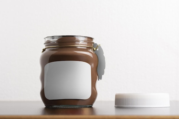 Foto grátis captura aproximada do frasco de chocolate espalhado com avelã com a tampa redonda sobre uma mesa preta