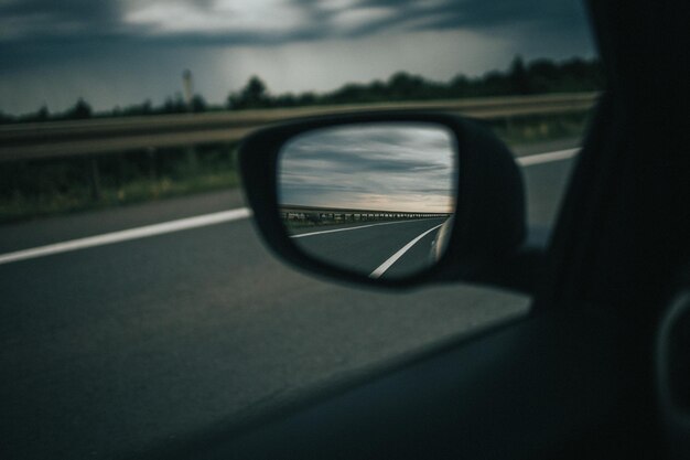Captura de foco seletivo da reflexão da rodovia em um espelho lateral do carro