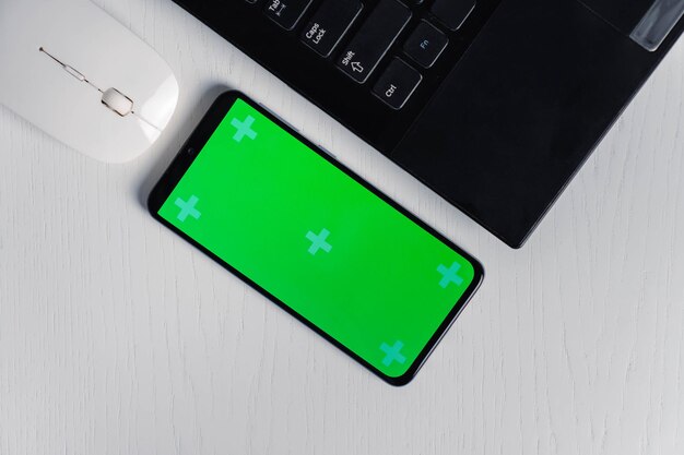 Captura plana de gadgets e dispositivos móveis em fundo branco maquete de tela verde para smartphone