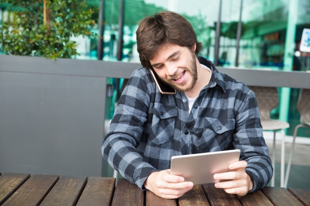 Foto grátis cara alegre assistindo vídeo na tela do gadget