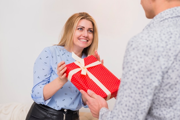 Foto grátis cara apresentando presente para feliz senhora