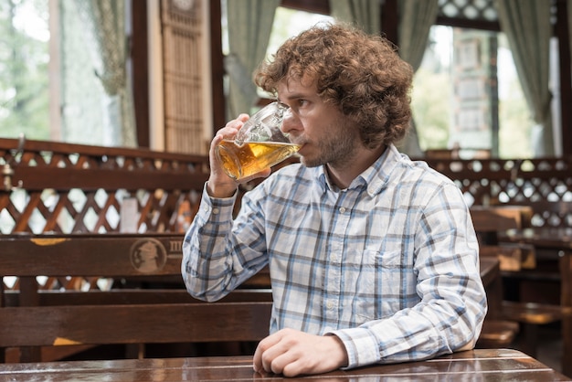 Foto grátis cara bonito, bebendo cerveja e olhando para longe