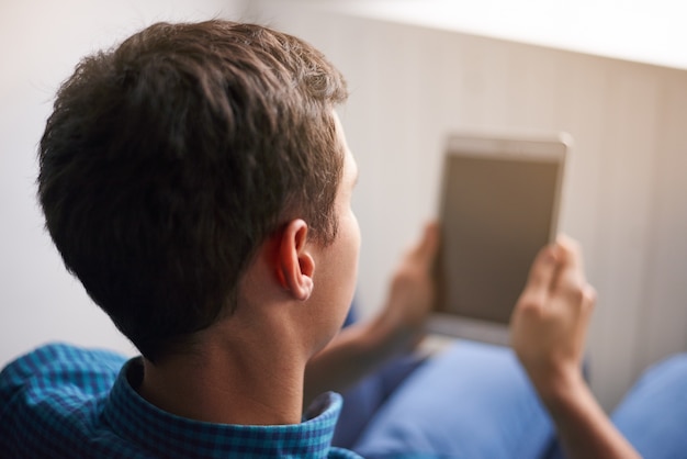 Foto grátis cara bonito de camisa azul usando tablet