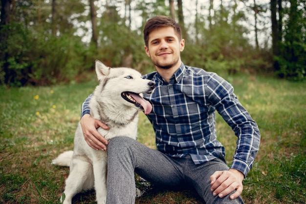 Cara bonito em um parque de verão com um cachorro