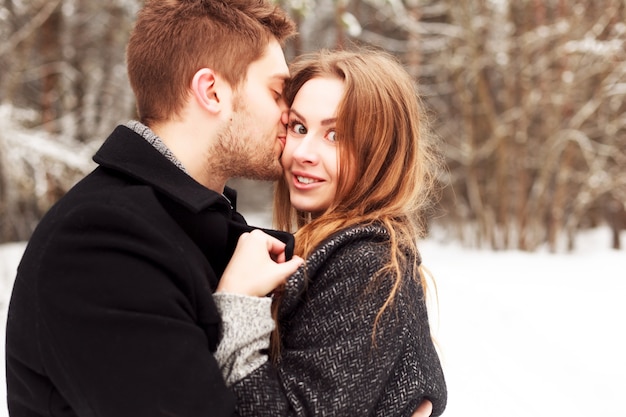 cara com barba por fazer beijando sua namorada alegre