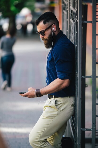 cara concentrado com o celular na rua