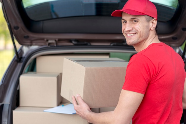 Foto grátis cara de entrega sorridente fazendo seu trabalho