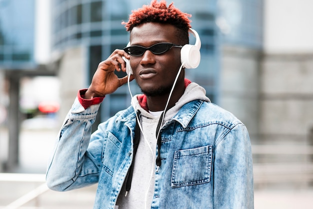 Cara de tiro médio com fones de ouvido e óculos de sol