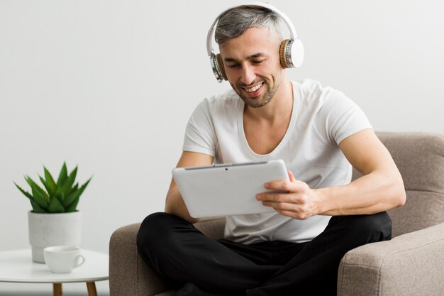 Cara de vista frontal com fones de ouvido, sentado em uma cadeira