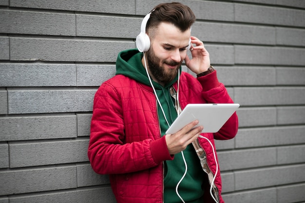 Cara de vista lateral com fones de ouvido e tablet