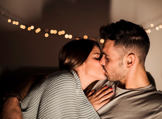 Cara jovem beijando com a senhora deitada no sofá