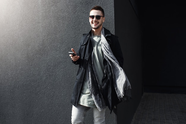 Cara jovem bonito com roupa de primavera legal em pé na rua.